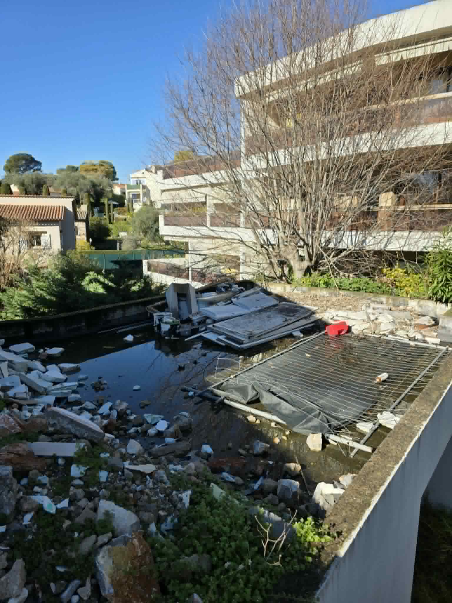Terrasse abandonnée gravats piscine avant évacuation