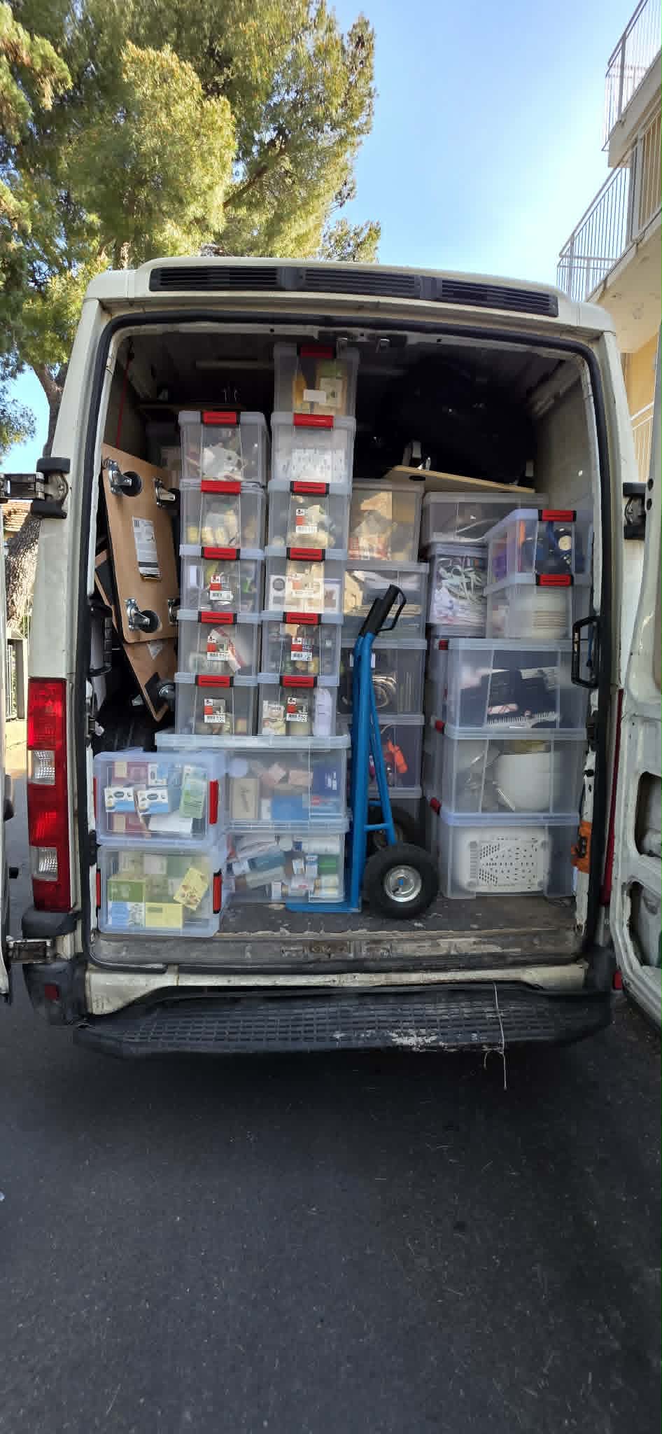 Utilitaire DTS chargé de bacs de rangement organisés et diable de manutention
