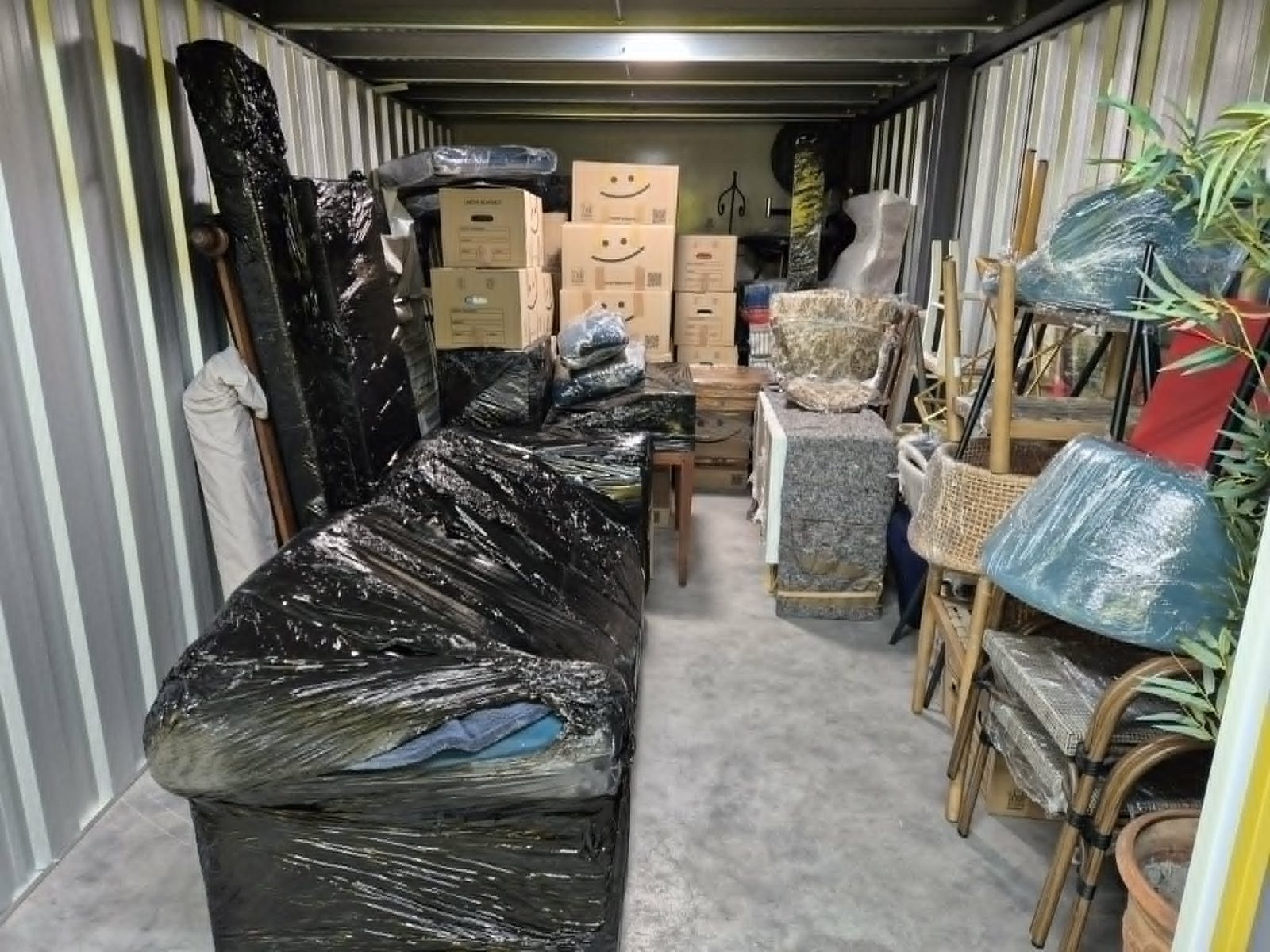 Box de garde-meuble DTS rempli de mobilier protégé, cartons et chaises rangés après déménagement